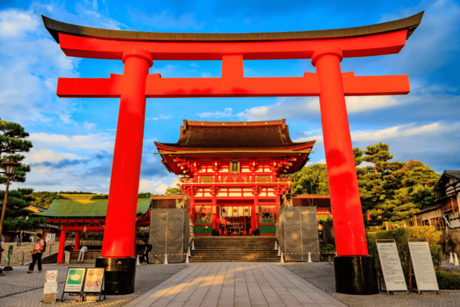 The massive bright vermilion torii gate at the entrance of the Fushimi Inari-taisha Shinto shrine in Kyoto, Japan