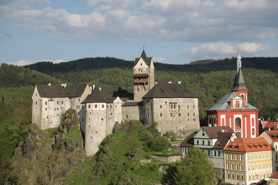 Loket Castle, a 12th-century Gothic stone fortress perched on a rocky cliffside in the Czech Republic.